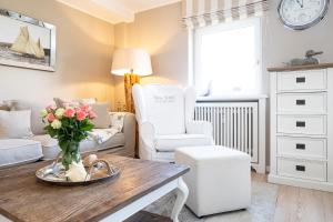 a living room with a vase of flowers on a table at Tunghoern-Hues in Keitum +4 photos