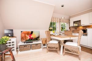 a kitchen and dining room with a table and chairs at Tunghoern-Hues in Keitum