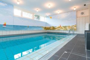 a swimming pool with a mural of the ocean at Tunghoern-Hues in Keitum