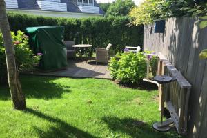 a backyard with a table and chairs and a fence at Tunghoern-Hues in Keitum