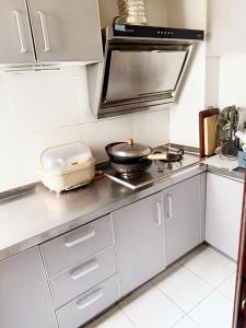 a kitchen with white cabinets and a stove top oven at Private room on the 6th floor in Beijing