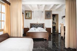 a bedroom with two beds and a table in it at Liva Mare - Serifos in Livadakia