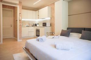 a large white bed in a room with a kitchen at BLUE WAVE by Design Studio in Bellano