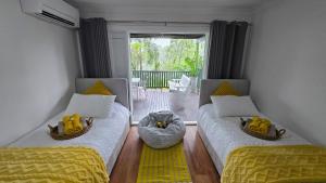 a living room with two beds and a balcony at The Hideaway Boutique Guest House in Jindalee