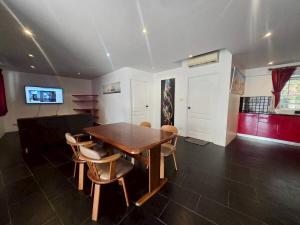 a dining room with a wooden table and chairs at Red House 12 in Ban Nong Pru