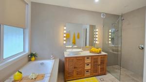 a bathroom with a tub and a sink and a shower at The Hideaway Boutique Guest House in Jindalee +19 photos