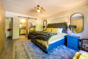 a bedroom with a blue bed and a mirror at Florie se Huis in Paarl