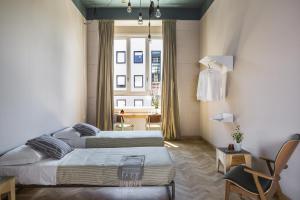 a bedroom with two beds and a table with a chair at casaBASE in Milan