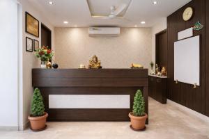 a lobby with a reception desk and two plants at Hotel YO94 in Indore