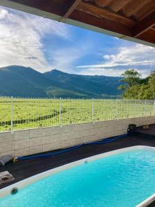 a swimming pool with a view of a vineyard at Residencial Moradas das cachoeiras 10 minutos da Praia Guarda Do Embaú SC in Palhoça