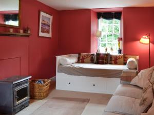 a red room with a bed and a window at Orchard Cottage - Uk12525 in Garlieston