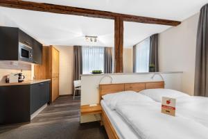 a hotel room with a bed and a kitchen at Schieners Hotel & Apfelhof Apartments in Wemding +77 photos