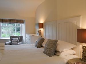 a bedroom with a bed and a chair and a window at Orchard Cottage - Uk12525 in Garlieston