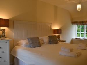 a bedroom with a large white bed with two pillows at Orchard Cottage - Uk12525 in Garlieston +12 photos