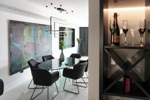 a dining room with a glass table and black chairs at Luxury Villa Black Cube with Heated pool in Mlini