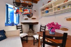 a living room with a table and a fireplace at Maison d'Elli in Mesochórion