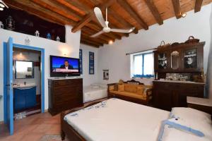 a bedroom with a bed and a bathroom with a tv at Maison d'Elli in Mesochórion