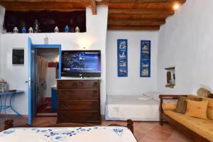 a living room with a television on a wooden dresser at Maison d'Elli in Mesochórion +7 photos