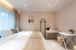 a bedroom with a large white bed and a desk at 4rest Stay Euljiro in Seoul