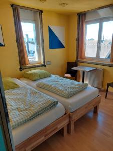 two beds in a room with two windows at Oldtown Hostel Otter in Zurich