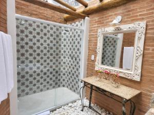 a bathroom with a shower and a mirror at Pousada Alto da Neblina in Monte Verde