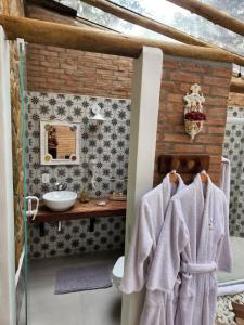 a bathroom with a toilet and a sink at Pousada Alto da Neblina in Monte Verde