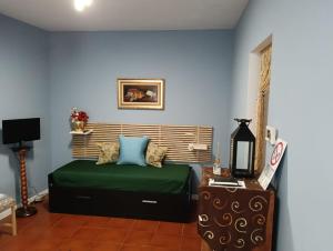 a bedroom with a green bed and blue walls at COZY Place 26 con PARCHEGGIO PRIVATO GRATUITO in Vercelli