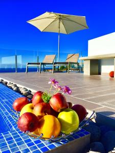 a bowl of fruit on a tray next to a pool at Villa Pinheira III heated pool in Calheta