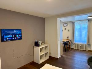 a living room with a tv on the wall at Downtown Apartments in Interlaken