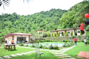 a group of people standing in the yard of a house at Fun N Forest Resort in Dehradun