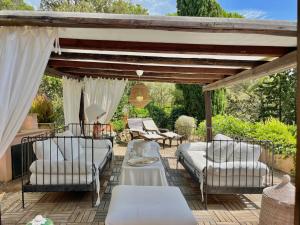 a patio with a table and chairs and a pergola at Porto Ercole Prestige Villa in Cala Galera