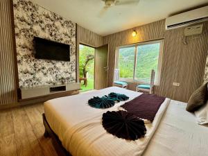 a bedroom with a bed with an umbrella on it at Fun N Forest Resort in Dehradun