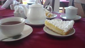 una mesa con un trozo de tarta y una taza de café en El Mirador Apart Hotel en Federación