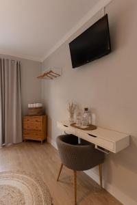 a room with a desk with a television on the wall at O VIOLAS - Art Coffee & Guesthouse in Praia de Mira