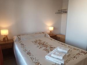 a bedroom with a bed with two lamps and two towels at Mi Espacio en Gualeguaychú in Gualeguaychú