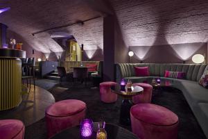a restaurant with pink chairs and tables and a bar at Dorint Parkhotel Jordanbad in Biberach an der Riß