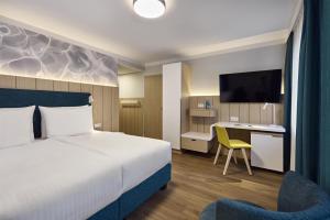a hotel room with a bed and a desk at Dorint Parkhotel Jordanbad in Biberach an der Riß