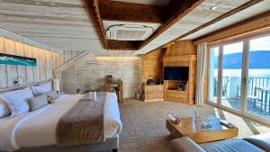 a bedroom with a large bed and a tv at Hôtel La Maison Bleue par Yoann CONTE in Veyrier-du-Lac
