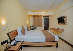 a hotel room with a bed and a television at Om Shiv Hotel Formerly The Treat Hotel in Madgaon