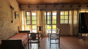 a room with a table and chairs and windows at El Campito in Villa Icho Cruz +3 photos