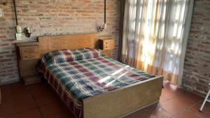 a bed in a room with a brick wall at El Campito in Villa Icho Cruz