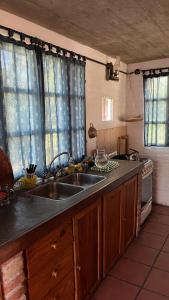 a kitchen with a sink and a stove at El Campito in Villa Icho Cruz