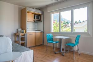 a living room with a table and chairs and a kitchen at La villa Du Port in Veyrier-du-Lac