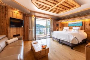 a bedroom with a large bed and a couch at Hôtel La Maison Bleue par Yoann CONTE in Veyrier-du-Lac +81 photos