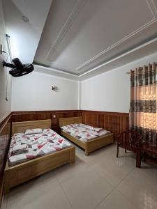two beds sitting in a room with at Hotel Ngân Lan in Ga Tam Quan