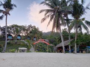 a playground on a beach with palm trees and a slide at Tress Maria's beach resort in Brother Islands