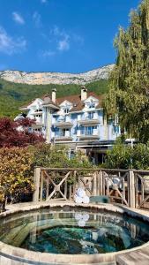 a large swimming pool in front of a building at Hôtel La Maison Bleue par Yoann CONTE in Veyrier-du-Lac