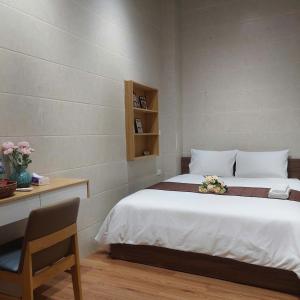 a bedroom with a bed and a table and a chair at Omeli homestay in Hanoi +83 photos