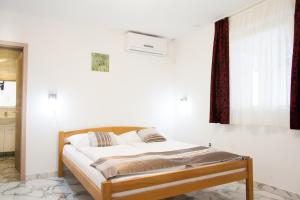 Bett in einem Zimmer mit einer weißen Wand in der Unterkunft Rooms Garden Zagreb Airport in Velika Gorica