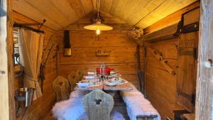 a long table in a wooden room with a tableablish at Hôtel La Maison Bleue par Yoann CONTE in Veyrier-du-Lac